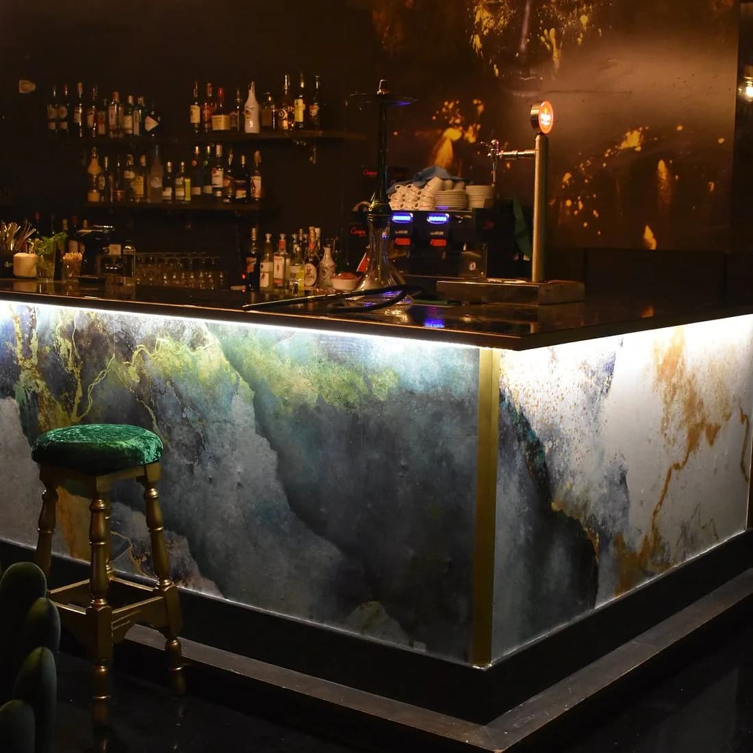 Barra de Karisma Lounge iluminada, con botellero y una cachimba montada